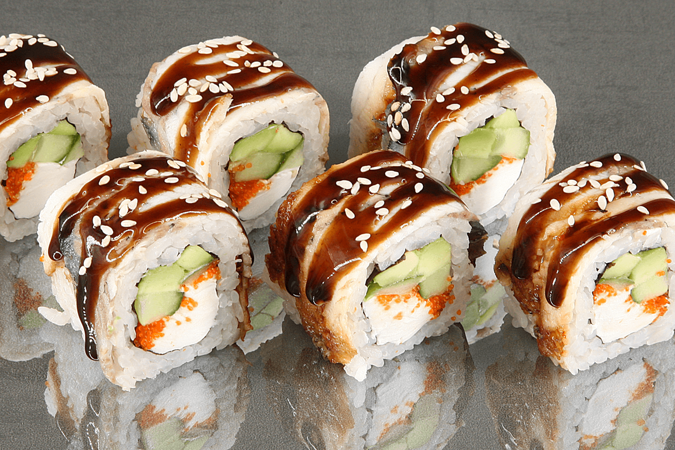 Вкуснейший ролл с огурцом, авокадо, мягким сливочным сыром и икрой капеллана масаго, обёрнутый угрём. Драгон