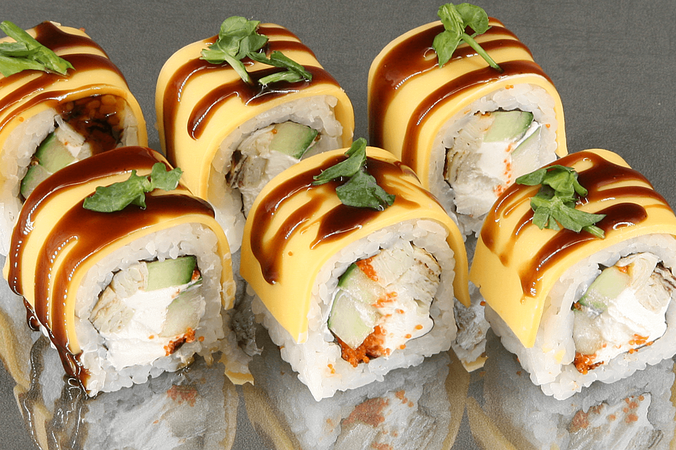 Оригинальный ролл со сливочным сыром, японским омлетом, огурцом и соусом унаги в пластинках сыра Чеддер, украшен микрозеленью. Чеддер