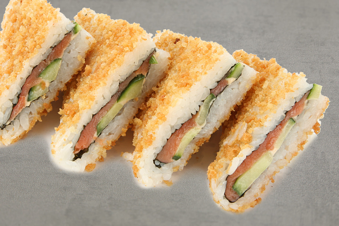 Суши-сэндвич. Оригинальные рисовые конвертики с начинкой из копчёного лосося и огурца, приправленные тайским соусом, в обсыпке из хрустящего кляра. Онигири Кранч