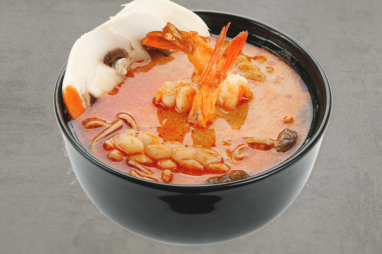 Тайский острый суп на кокосовом молоке, с тигровыми креветками, кальмаром, мидиями и грибами. Том Ям